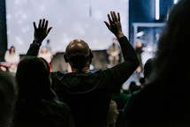 Man with his hands raised in the air during worship. 