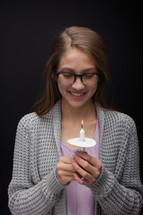 a teen girl holding a candle 