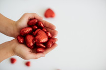 cupped hands holding red valentines hearts 