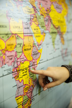 finger pointing to a map of Africa 