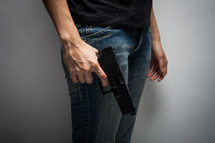 a man holding a pistol at his side 