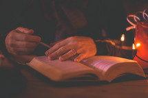 a man reading a Bible near Christmas lights 