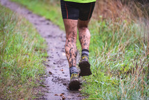 man running on a muddy trail 