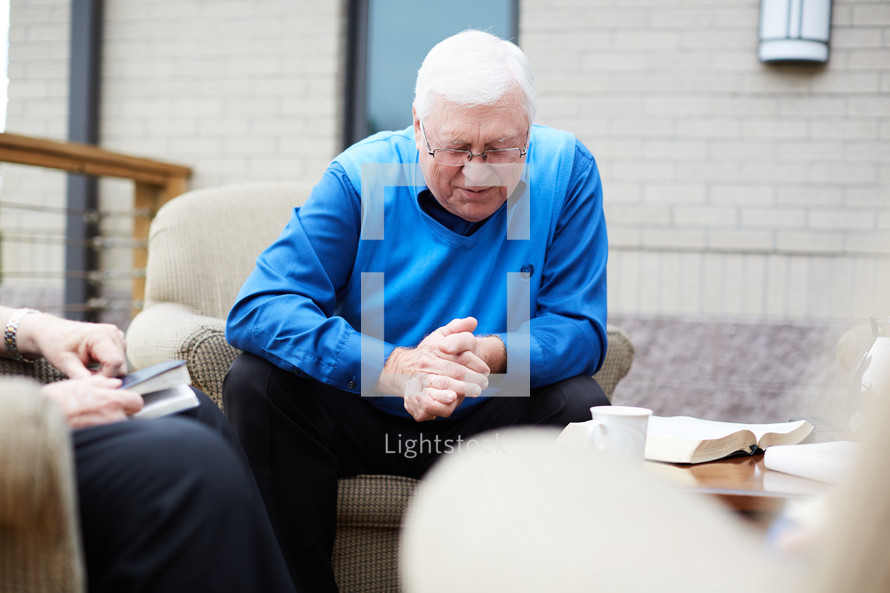 senior men's Bible study praying 