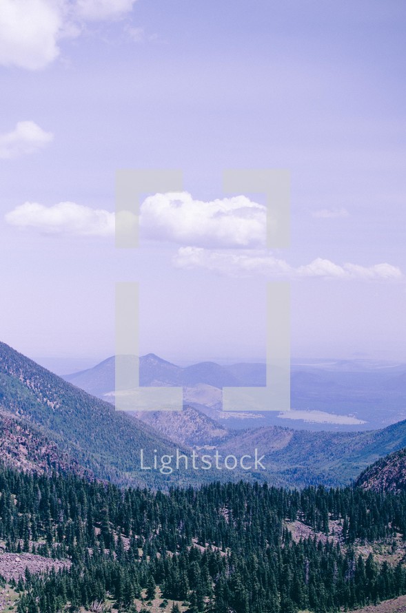 clouds in the sky over a mountain forest 