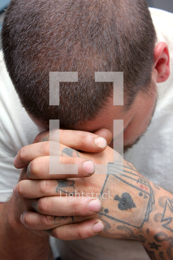 tattooed hands praying