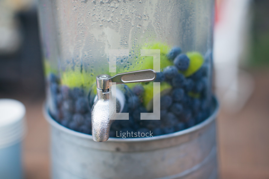 blueberries and limes in a drink 