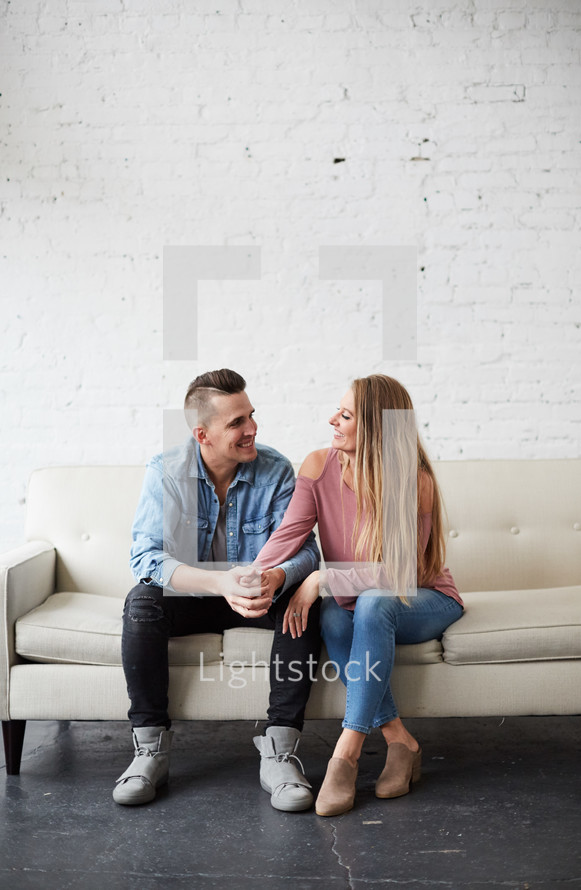a couple sitting on a couch talking 