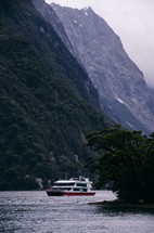 boat on a lake surrounded by mountains 