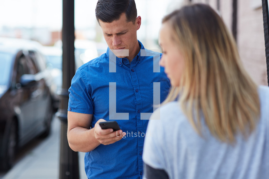 a man texting and a frustrated woman 