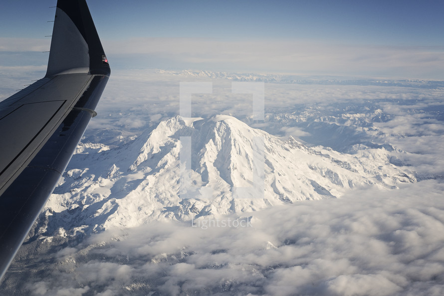 plane flying over a snow capped mountain 