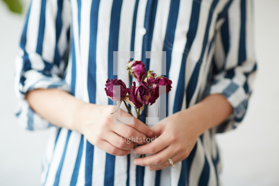 a woman holding dried roses 