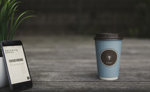 coffee cup with a cross and calendar app on a cellphone 
