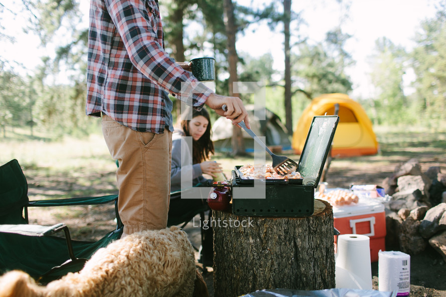 a man cooking breakfast while camping 