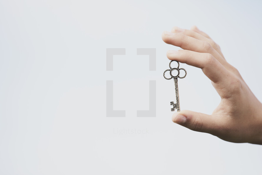 Hand holding a silver key.