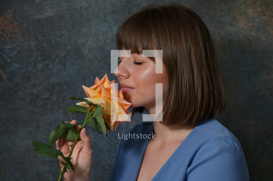 Woman Holding And Smelling A Rose Flower