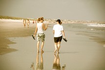 women walking and talking on a beach 