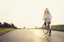 woman riding a bicycle on a road