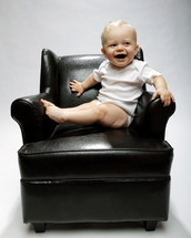 infant boy in a leather chair 
