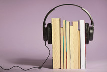 Audio books concept with books and headphones in studio