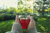 female holding a cup of hot tea outdoors 