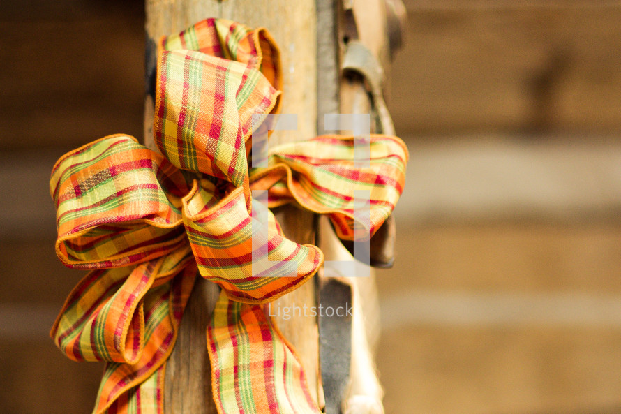 Thanksgiving bow wrapped around an old wooden pole.