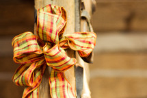 Thanksgiving bow wrapped around an old wooden pole.