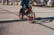 child riding a bike in a parking lot 