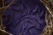 a crown of thorns on purple fabric 
