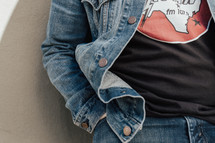 torso of a man in a denim jacket and blue jeans 