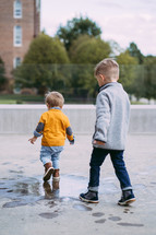 brothers splashing in a puddle 
