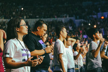 people in a stadium worshiping God 