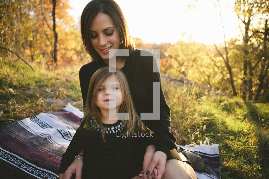 girl child sitting in her mother's lap