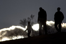 silhouettes walking on a mountaintop 