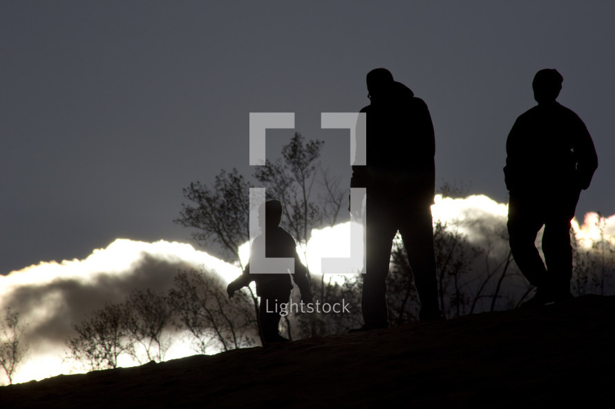 silhouettes walking on a mountaintop 