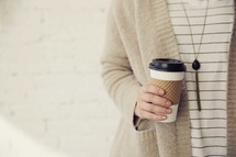 woman holding a paper coffee cup 
