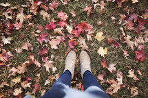 feet standing in fall leaves.
