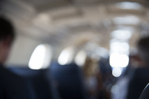 blurred people sitting on an airplane.