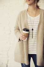 woman holding a paper coffee cup 