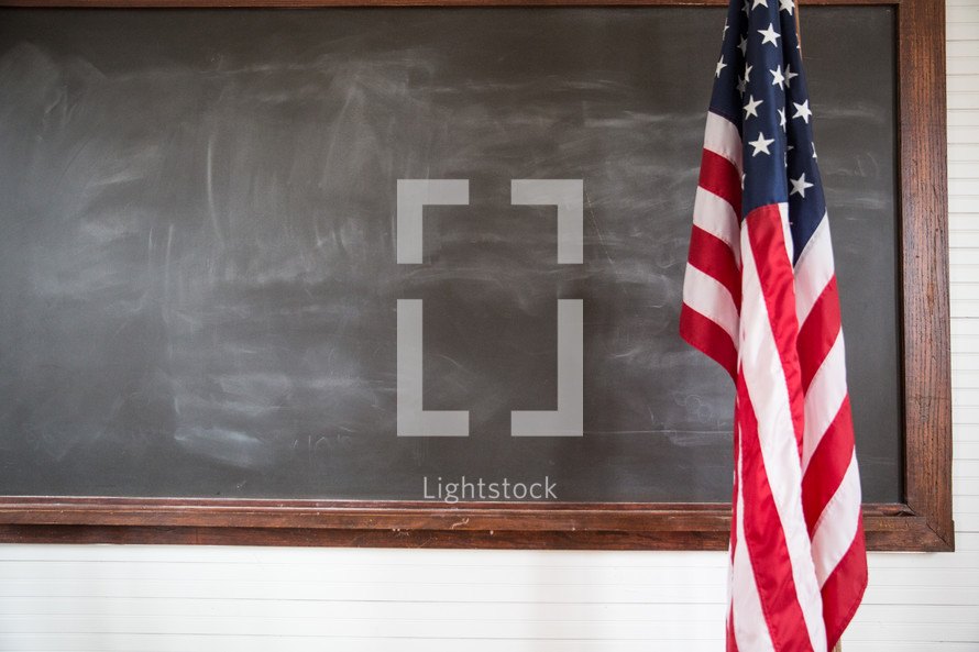 American flag and blackboard in a schoolhouse. 
