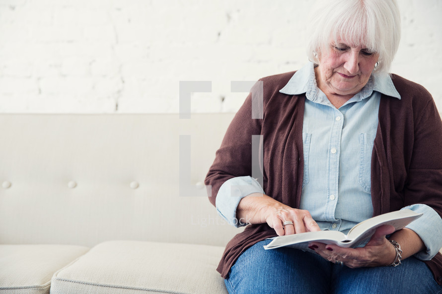 an elderly woman reading the Bible