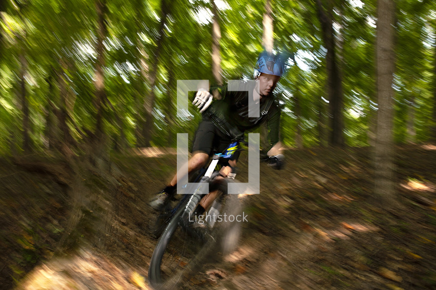 a boy riding a bicycle in a forest 