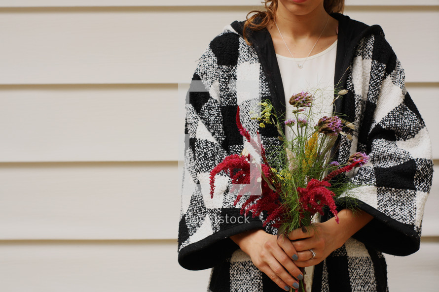 a woman holding a fall bouquet 