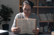 Woman praying while holding a bible