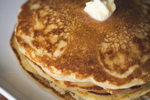 butter on a stack of pancakes 