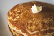 butter on a stack of pancakes 