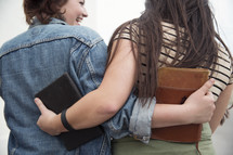 young women hugging holding Bibles 