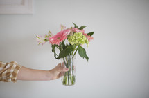 a woman holding flowers in a vase 