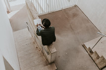 man reading a Bible in a stairwell 