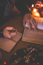 a man reading a Bible and writing in a journal at Christmas 